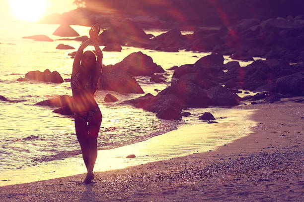 istock girl standing on the beach sea sunset rays 492041138