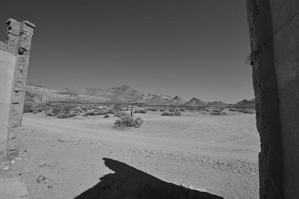 Rhyolite is a ghost town in Nye County, in the U.S. state of Nevada. It is in the Bullfrog Hills, about 120 miles (190 km) northwest of Las Vegas, near the eastern edge of Death Valley. The town began in early 1905 as one of several mining camps that sprang up after a prospecting discovery in the surrounding hills. During an ensuing gold rush, thousands of gold-seekers, developers, miners and service providers flocked to the Bullfrog Mining District. Many settled in Rhyolite, which lay in a sheltered desert basin near the region's biggest producer, the Montgomery Shoshone Mine.