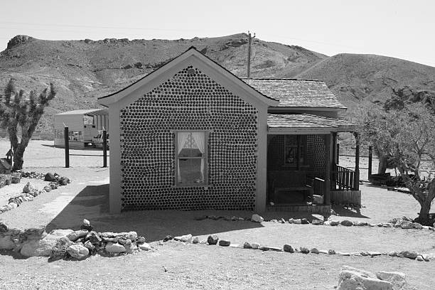 Rhyolite is a ghost town in Nye County, in the U.S. state of Nevada. It is in the Bullfrog Hills, about 120 miles (190 km) northwest of Las Vegas, near the eastern edge of Death Valley. The town began in early 1905 as one of several mining camps that sprang up after a prospecting discovery in the surrounding hills. During an ensuing gold rush, thousands of gold-seekers, developers, miners and service providers flocked to the Bullfrog Mining District. Many settled in Rhyolite, which lay in a sheltered desert basin near the region's biggest producer, the Montgomery Shoshone Mine.