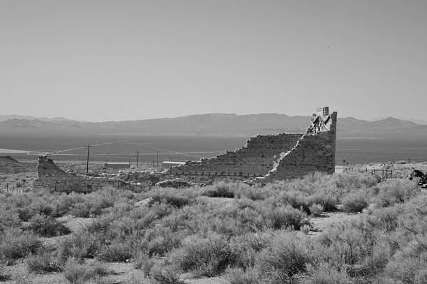 Rhyolite is a ghost town in Nye County, in the U.S. state of Nevada. It is in the Bullfrog Hills, about 120 miles (190 km) northwest of Las Vegas, near the eastern edge of Death Valley. The town began in early 1905 as one of several mining camps that sprang up after a prospecting discovery in the surrounding hills. During an ensuing gold rush, thousands of gold-seekers, developers, miners and service providers flocked to the Bullfrog Mining District. Many settled in Rhyolite, which lay in a sheltered desert basin near the region's biggest producer, the Montgomery Shoshone Mine.