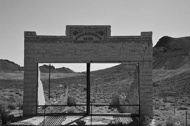 Rhyolite is a ghost town in Nye County, in the U.S. state of Nevada. It is in the Bullfrog Hills, about 120 miles (190 km) northwest of Las Vegas, near the eastern edge of Death Valley. The town began in early 1905 as one of several mining camps that sprang up after a prospecting discovery in the surrounding hills. During an ensuing gold rush, thousands of gold-seekers, developers, miners and service providers flocked to the Bullfrog Mining District. Many settled in Rhyolite, which lay in a sheltered desert basin near the region's biggest producer, the Montgomery Shoshone Mine.