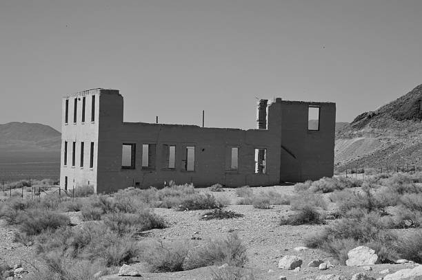Rhyolite is a ghost town in Nye County, in the U.S. state of Nevada. It is in the Bullfrog Hills, about 120 miles (190 km) northwest of Las Vegas, near the eastern edge of Death Valley. The town began in early 1905 as one of several mining camps that sprang up after a prospecting discovery in the surrounding hills. During an ensuing gold rush, thousands of gold-seekers, developers, miners and service providers flocked to the Bullfrog Mining District. Many settled in Rhyolite, which lay in a sheltered desert basin near the region's biggest producer, the Montgomery Shoshone Mine.