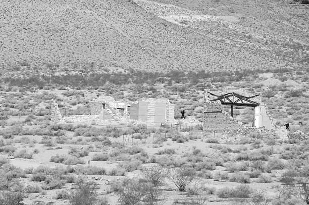 Rhyolite is a ghost town in Nye County, in the U.S. state of Nevada. It is in the Bullfrog Hills, about 120 miles (190 km) northwest of Las Vegas, near the eastern edge of Death Valley. The town began in early 1905 as one of several mining camps that sprang up after a prospecting discovery in the surrounding hills. During an ensuing gold rush, thousands of gold-seekers, developers, miners and service providers flocked to the Bullfrog Mining District. Many settled in Rhyolite, which lay in a sheltered desert basin near the region's biggest producer, the Montgomery Shoshone Mine.