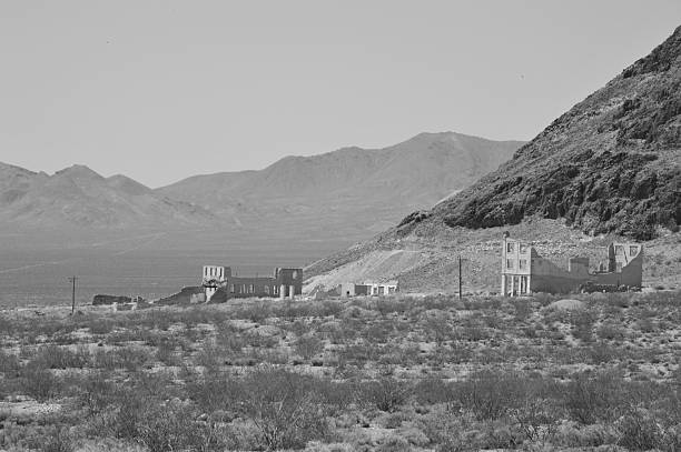 Rhyolite is a ghost town in Nye County, in the U.S. state of Nevada. It is in the Bullfrog Hills, about 120 miles (190 km) northwest of Las Vegas, near the eastern edge of Death Valley. The town began in early 1905 as one of several mining camps that sprang up after a prospecting discovery in the surrounding hills. During an ensuing gold rush, thousands of gold-seekers, developers, miners and service providers flocked to the Bullfrog Mining District. Many settled in Rhyolite, which lay in a sheltered desert basin near the region's biggest producer, the Montgomery Shoshone Mine.