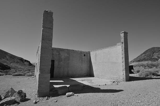 Rhyolite is a ghost town in Nye County, in the U.S. state of Nevada. It is in the Bullfrog Hills, about 120 miles (190 km) northwest of Las Vegas, near the eastern edge of Death Valley. The town began in early 1905 as one of several mining camps that sprang up after a prospecting discovery in the surrounding hills. During an ensuing gold rush, thousands of gold-seekers, developers, miners and service providers flocked to the Bullfrog Mining District. Many settled in Rhyolite, which lay in a sheltered desert basin near the region's biggest producer, the Montgomery Shoshone Mine.