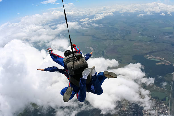 Tandem jump in the sky with clouds.