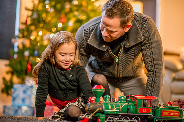 istock Father and Daughter Watching a Toy Train 492043054