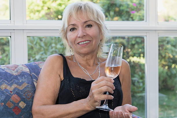 istock Senior mature blond woman is sitting on a couch 492044162