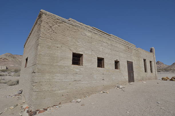 Rhyolite is a ghost town in Nye County, in the U.S. state of Nevada. It is in the Bullfrog Hills, about 120 miles (190 km) northwest of Las Vegas, near the eastern edge of Death Valley. The town began in early 1905 as one of several mining camps that sprang up after a prospecting discovery in the surrounding hills. During an ensuing gold rush, thousands of gold-seekers, developers, miners and service providers flocked to the Bullfrog Mining District. Many settled in Rhyolite, which lay in a sheltered desert basin near the region's biggest producer, the Montgomery Shoshone Mine.