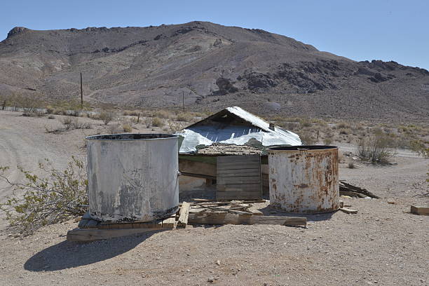 Rhyolite is a ghost town in Nye County, in the U.S. state of Nevada. It is in the Bullfrog Hills, about 120 miles (190 km) northwest of Las Vegas, near the eastern edge of Death Valley. The town began in early 1905 as one of several mining camps that sprang up after a prospecting discovery in the surrounding hills. During an ensuing gold rush, thousands of gold-seekers, developers, miners and service providers flocked to the Bullfrog Mining District. Many settled in Rhyolite, which lay in a sheltered desert basin near the region's biggest producer, the Montgomery Shoshone Mine.