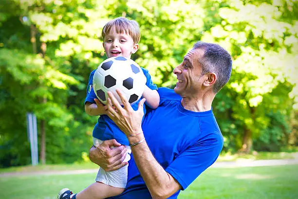 Photo of Father and  toddler playing with soccer ball