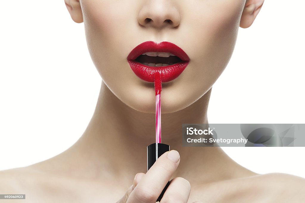 Girl with red lips Closeup portrait of beautiful girl putting on red lipstick Lipstick Stock Photo