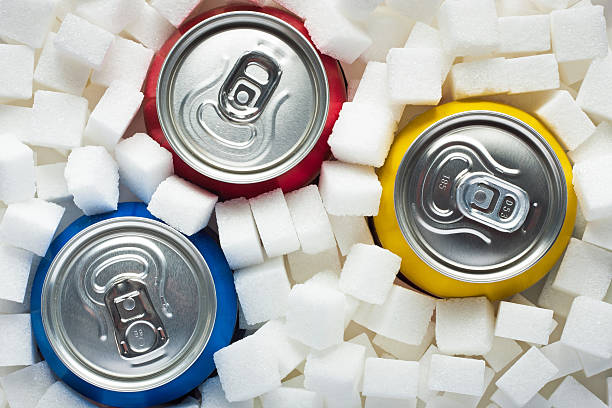 Sugar in food Unhealthy food concept - sugar in carbonated drinks. Sugar cubes as background and canned drinks cold drink stock pictures, royalty-free photos & images