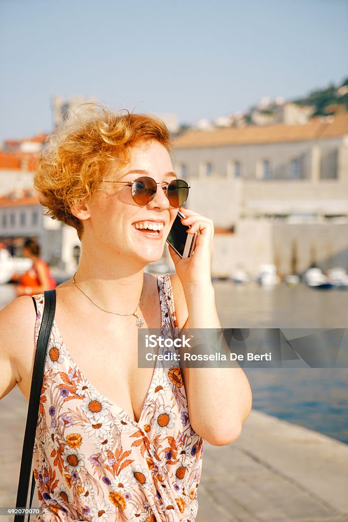 Young Cheerful Woman On The Phone Portrait of cheerful young woman old city on the background. 20-29 Years Stock Photo