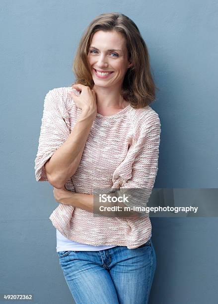 Alegre Mujer De Mediana Edad Sonriendo En Jeans Y Jersey Foto de stock y más banco de imágenes de Mujeres