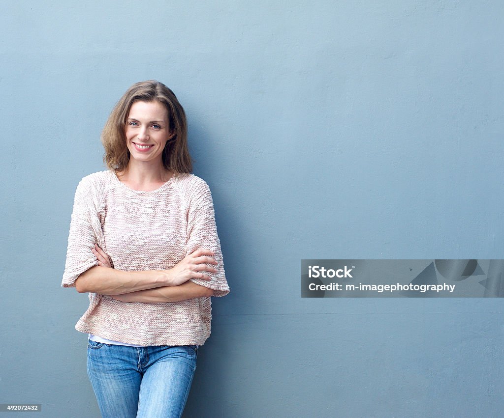 Feliz meados mulher adulta sorrindo com braços cruzados - Foto de stock de Mulheres royalty-free