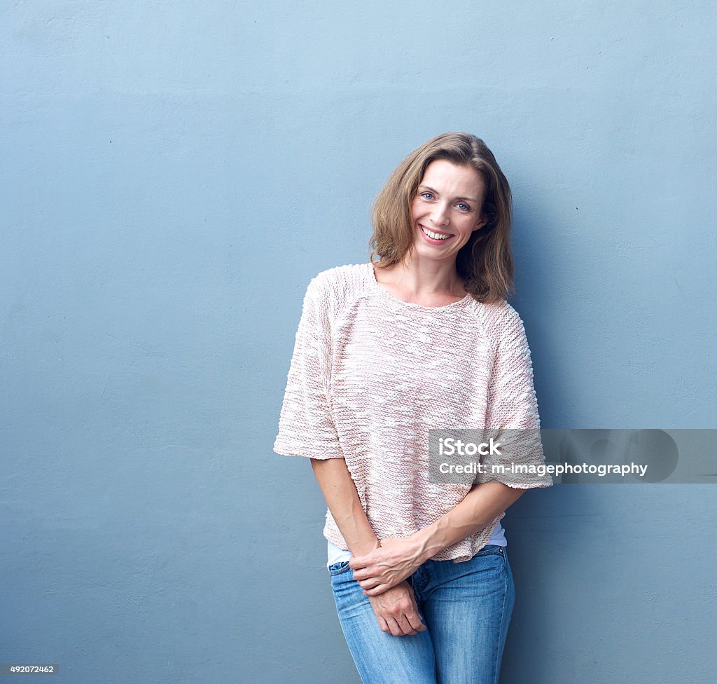 Atraente meados mulher adulta sorrindo em Fundo cinza - Foto de stock de Retrato royalty-free