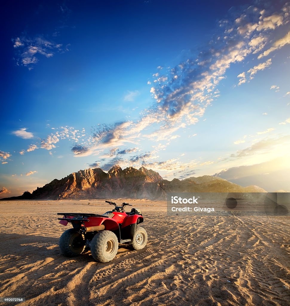 Quad bike in desert Quad bike in sand desert near mountain Desert Area Stock Photo