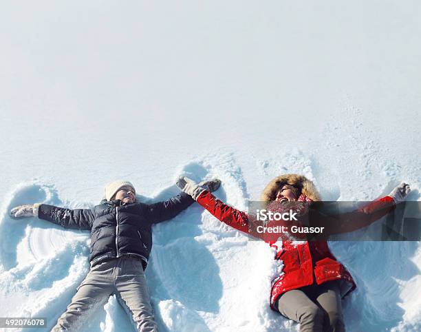 Happy Mother Son Playing Having Fun Lying In Snow Winter Stock Photo - Download Image Now