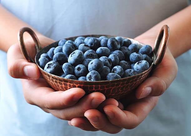 istock Ripe blueberries in children's hands 492076272