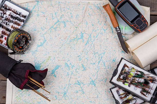istock fly-fishing tackles on paper map background 492076408