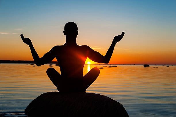 istock Meditating man silhouette on multicolored sunset background. 492077814