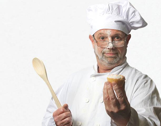 istock Portrait of chef holding out a cupcake 492080348