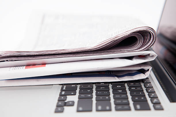 istock Newspapers resting on laptop keyboard 492081590