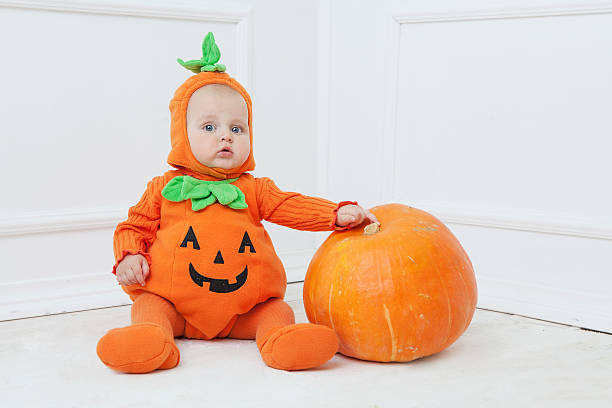 istock Child in pumpkin suit on white background 492082068