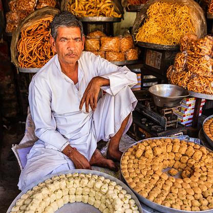 Indian street vendor seeling sweets near Jaipur. Jaipur is the capital city of Rajasthan. Jaipur is known as the Pink City, because of the color of the stone exclusively used for the construction of all the structures.