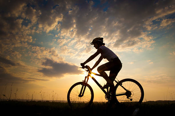 istock Biker-girl at the sunset on the meadow 492084328