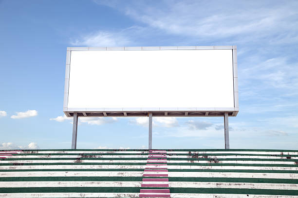 empty open asphalt road on the green fields at sunny Empty white digital billboard screen for advertising in stadium , with clipping path stadium advertising stock pictures, royalty-free photos & images