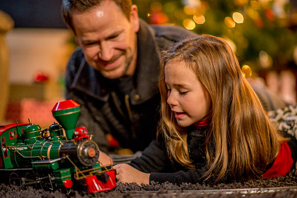 istock Father and Daughter Playing by the Christmas Tree 492096342