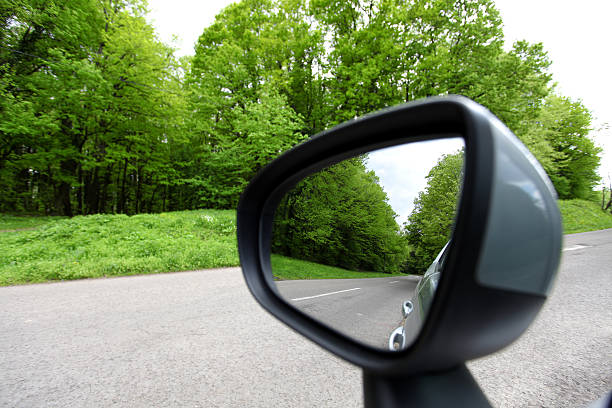 istock forest road reflection,  rearview car driving mirror view green 492096402