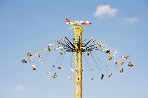 Munich, Germany - September 30, 2015: People in a high chairoplane on the Oktoberfest in Munich. The Oktoberfest is the biggest beer festival of the world with over 6 million visitors each year. Foto taken from Theresienwiese.