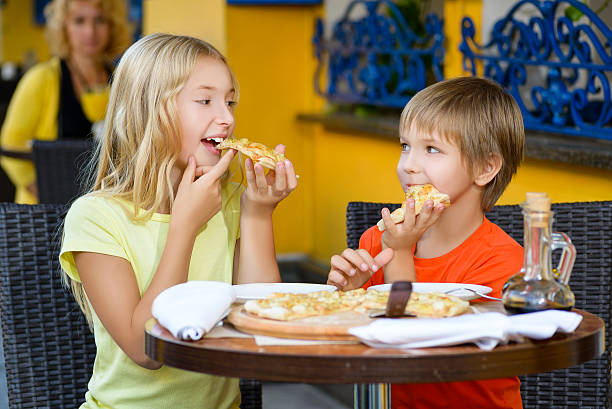 istock Happy children indoors eating pizza smiling 492106958