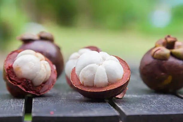mangosteens on a wooden table, close up image