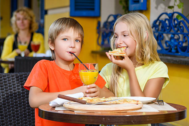 istock Happy or satisfied boy width girl eating pizza and drinking 492107184