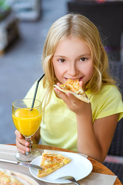 istock Pretty girls smiling when drinking juice and eating pizza 492107552