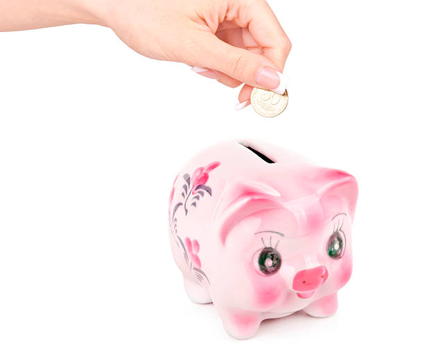 istock Woman's hand dropping a coin piggy bank 492107866