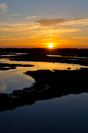 The setting sun over the Intercoastal Waterway, creates stunning colors reflected in the meandering creeks and marshland at low tide.