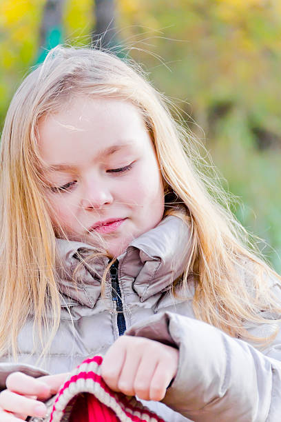 istock Cute girl puts on red hat 492118550