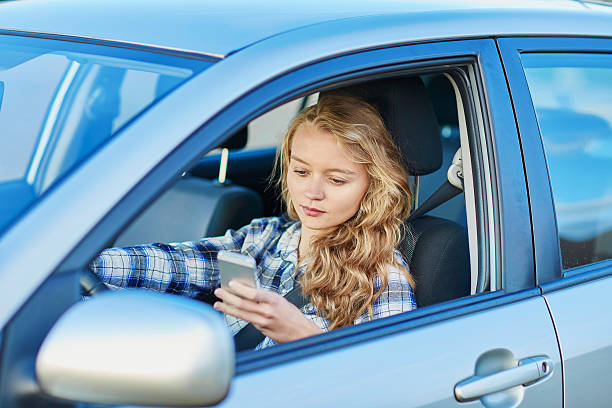 femme à l'aide de son smartphone conduire une voiture - reckless driving photos et images de collection