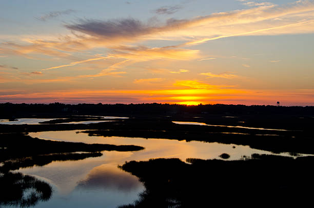 The setting sun over the Intercoastal Waterway, creates stunning colors reflected in the meandering creeks and marshland at low tide.