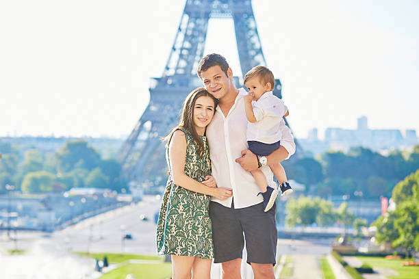 famiglia felice di tre nella parte anteriore della torre eiffel - family eiffel tower baby vacations foto e immagini stock