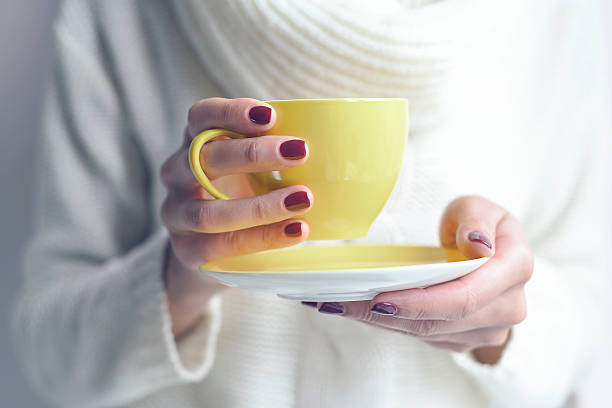 istock Cup of tea or coffee in female hands 492128386