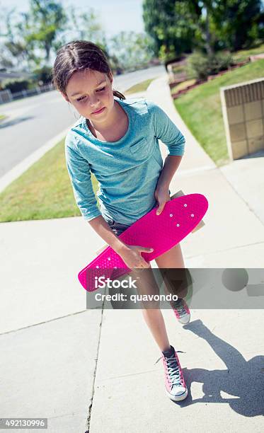 Girl Walking Down The Sidewalk With Skateboard Stock Photo - Download Image Now - 2015, Cheerful, Child