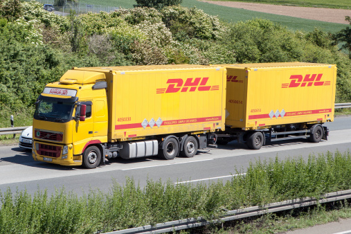 Wiesbaden, Germany - May 16, 2014: A truck of DHL on German highway A66 nearby Wiesbadener Kreuz. DHL is part of Deutsche Post providing international mail services. Operating under the name Deutsche Post DHL it is the world's largest logistics group.