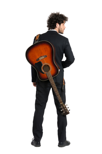 Portrait Of Elegant Man Carrying Guitar Over White Background