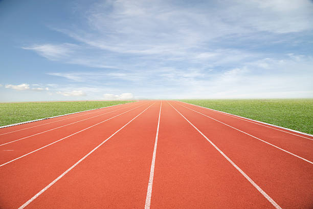 istock Running track with green grass and blue sky white cloud. 492146918